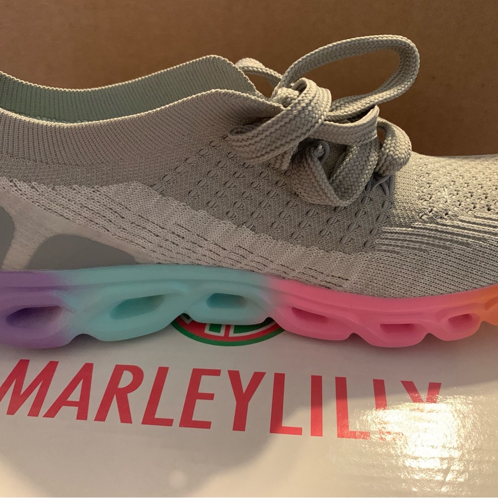 Gray tennis shoes with colored soles